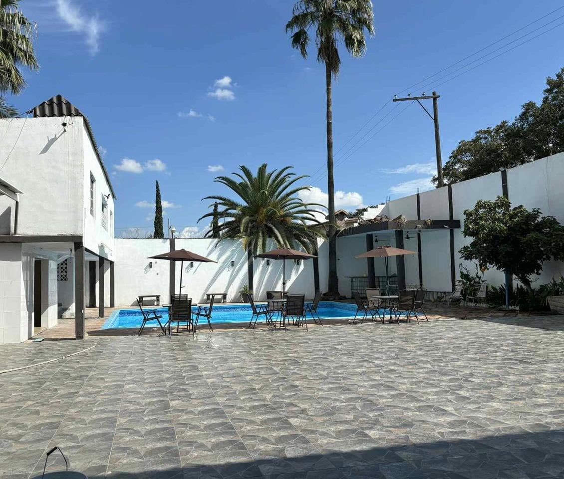 Patio principal de la quinta con alberca y palmeras